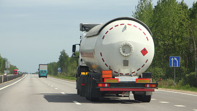 Photographie d’un camion-citerne au milieu d’une autoroute à trois voies