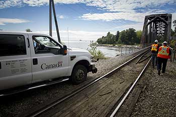 Rail inspectors examine the infrastructure of a railway crossing over a bridge